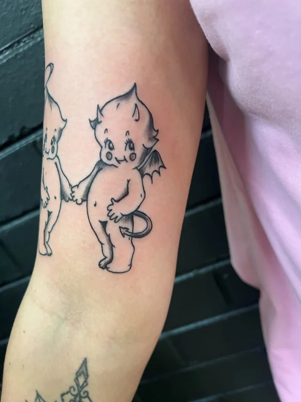 Fine-line cartoon character tattoo on an arm