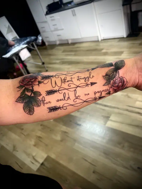 Floral tattoo with lettering on a forearm